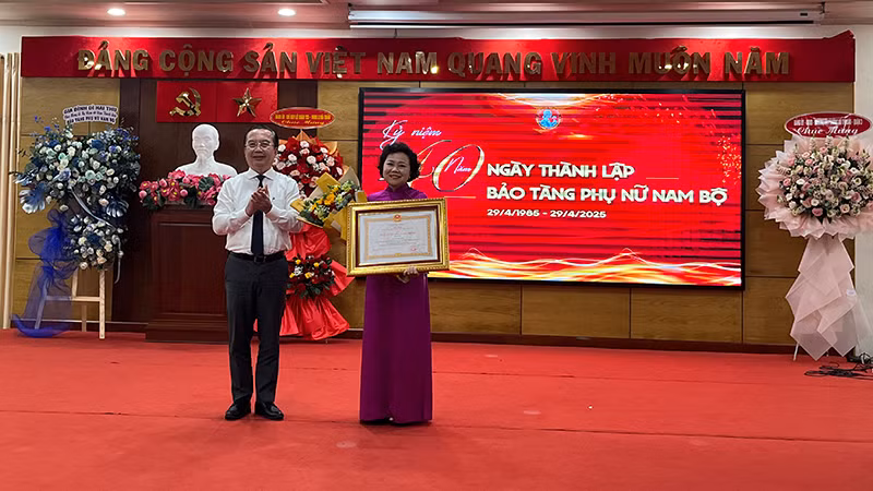 Ông Trần Thế Thuận, Giám đốc Sở Văn hóa và Thể thao Thành phố Hồ Chí Minh trao Huân chương Lao động hạng III cho bà Nguyễn Thị Thắm, nguyên Giám đốc Bảo tàng Phụ nữ Nam Bộ. (Ảnh M.H)