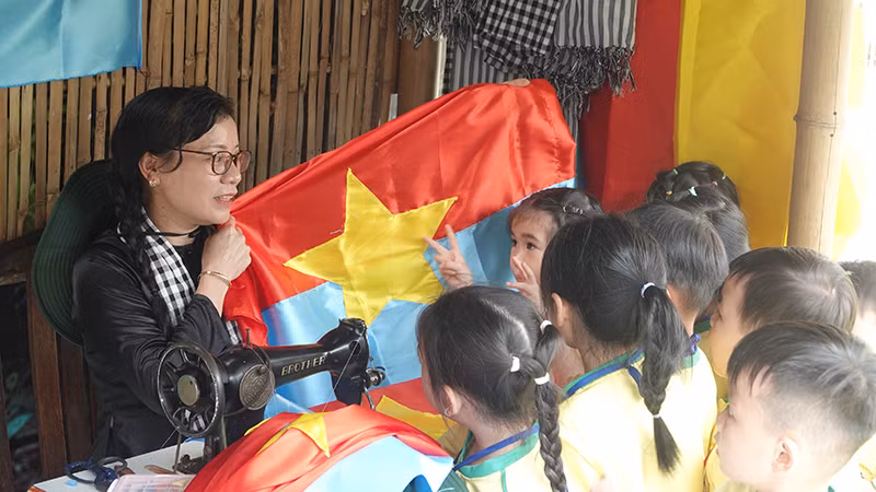 Các em nhỏ tìm hiểu về cờ giải phóng tại buổi khai mạc triển lãm. (Ảnh: MẠNH HẢO)