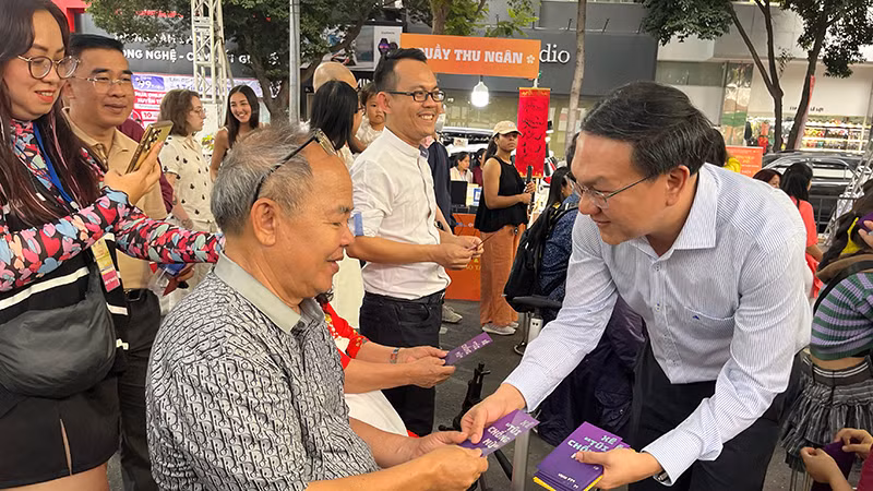Giám đốc Sở Thông tin và Truyền thông Thành phố Hồ Chí Minh Lâm Đình Thắng lì xì sách cho khách tham dự chương trình.