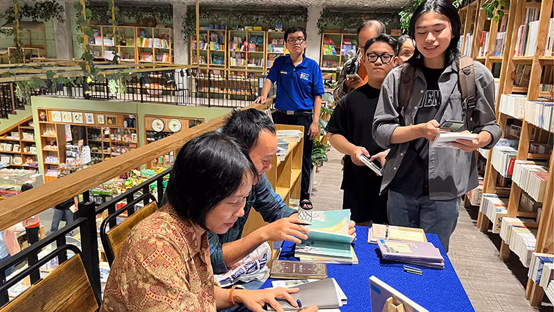 Nhà văn Nguyễn Ngọc Tư ký tặng sách cho bạn đọc trong sáng 26/4. (Ảnh M.H).