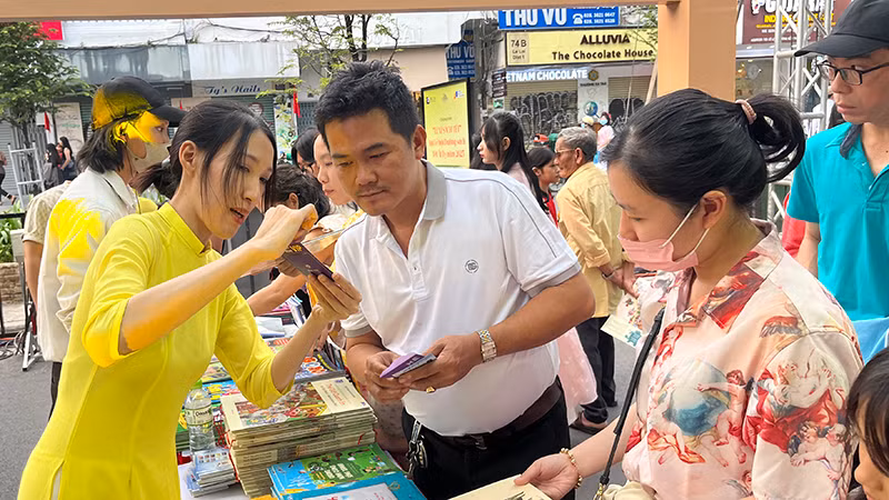 Nhân viên hướng dẫn du khách cách sử dụng khi được nhận lì xì tài khoản sách nói.