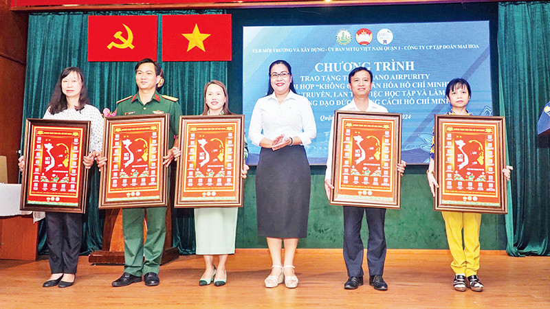 Các thành viên Mặt trận Tổ quốc Quận 1 tiếp nhận tranh "Không gian văn hóa Hồ Chí Minh" tích hợp mã QR.