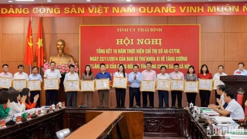 Phó Chủ tịch Thường trực Ủy ban nhân dân tỉnh Thái Bình Nguyễn Quang Hưng, Trưởng Ban đại diện Hội đồng quản trị Ngân hàng Chính sách xã hội tỉnh Thái Bình trao Bằng khen cho các tập thể và cá nhân đạt thành tích xuất sắc trong thực hiện Chỉ thị 40-CT/TW.