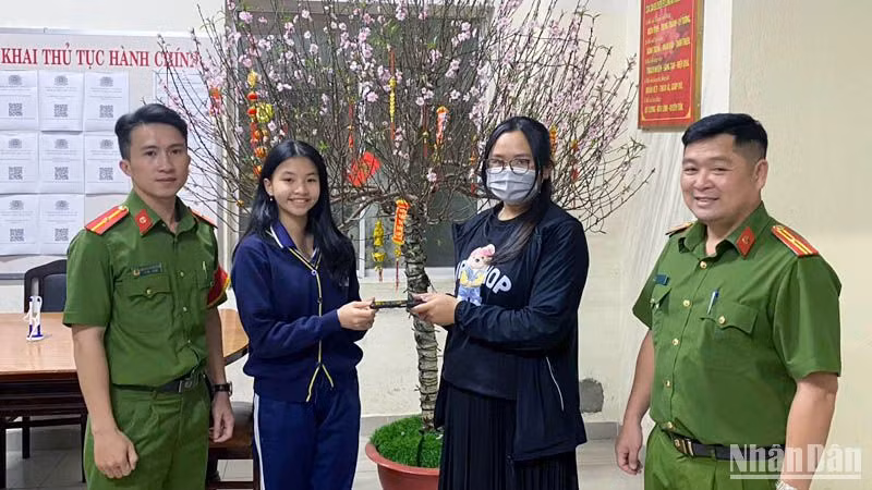 Em Võ Quỳnh Thư trao lại chiếc điện thoại cho chị Kim Oanh.