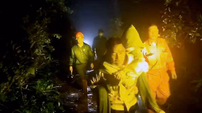 Lực lượng cứu hộ cõng sinh viên xuống núi.