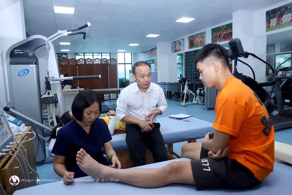 TS. BS Nguyễn Văn Phú – Trưởng phòng Y học thể thao (Liên đoàn Bóng đá Việt Nam) kiểm tra tình trạng chấn thương cổ chân của tiền đạo Đình Bắc. (Ảnh: VFF)