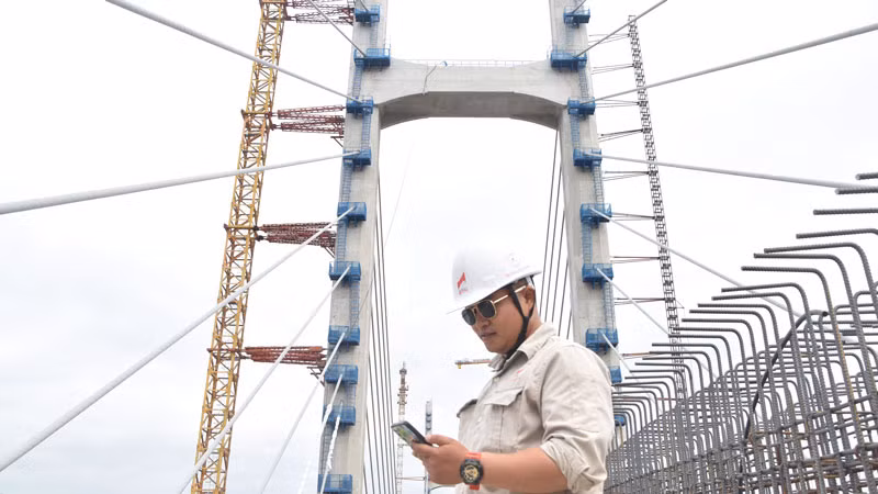 Tranh thủ giờ giải lao, anh Dương Văn Nguyên, cán bộ kỹ thuật phụ trách thi công của Công ty cổ phần Xây dựng và Lắp máy Trung Nam gọi điện về hỏi thăm gia đình trong ngày Tết Dương lịch.