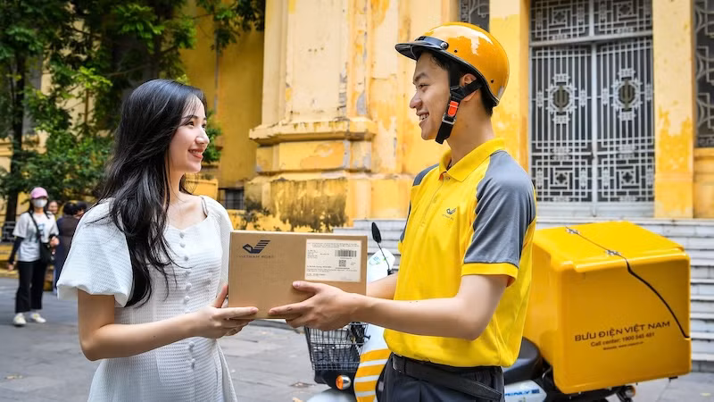 Nhân viên bưu điện phát bưu gửi đến tay khách hàng