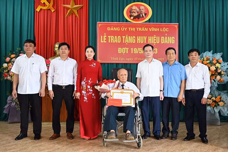 Đồng chí Lê Thị Kim Dung, Phó Bí thư Thường trực Tỉnh ủy, Chủ tịch Hội đồng nhân dân tỉnh Tuyên Quang trao Huy hiệu 75 năm tuổi Đảng và tặng hoa chúc mừng đảng viên Ma Phúc Tiến, Đảng bộ thị trấn Vĩnh Lộc, huyện Chiêm Hóa.