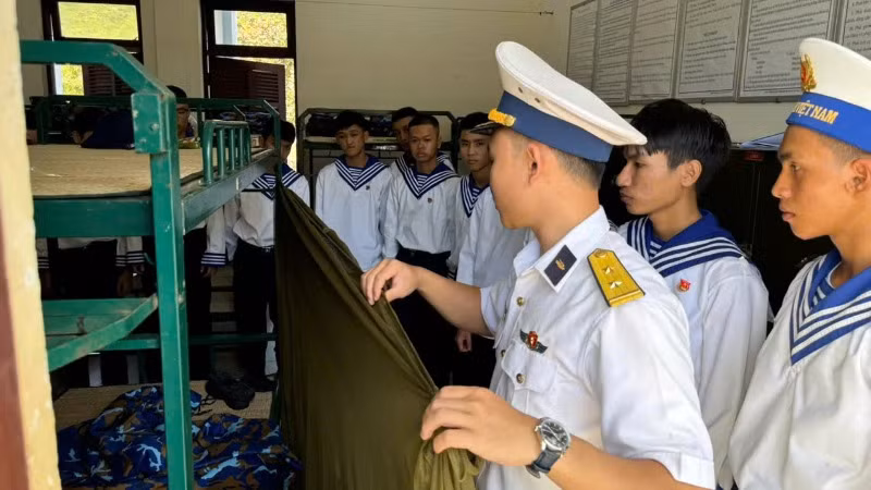 Hướng dẫn chiến sĩ mới gấp chăn màn.