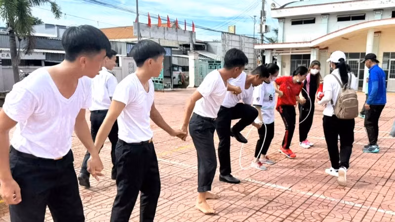 Cán bộ, chiến sĩ Trung tâm Bảo đảm Hậu cần-Kỹ thuật và hội viên Hội Liên hiệp Phụ nữ xã Hàng Vịnh (Cà Mau) tham gia trò chơi di chuyển qua vòng.