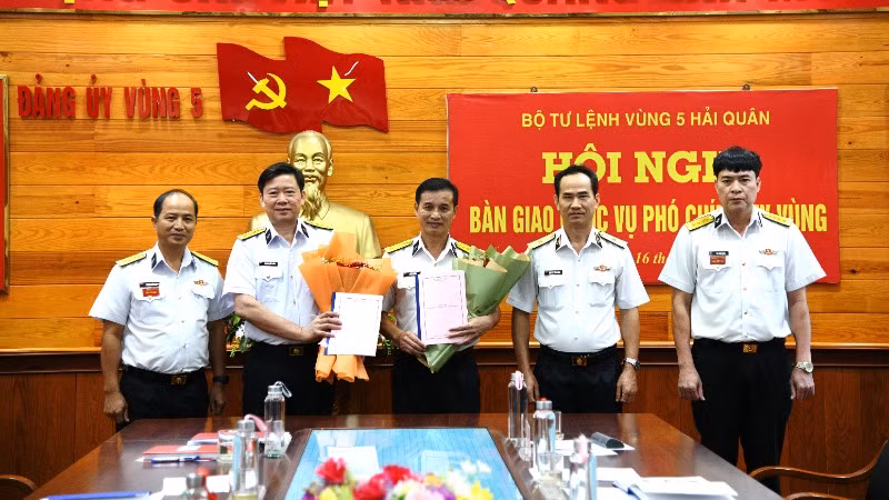 Chuẩn Đô đốc Nguyễn Hữu Thoan (thứ hai từ phải qua) tặng hoa chúc mừng Đại tá Lê Văn Hưởng và Đại tá Hoàng Quốc Hoàn.