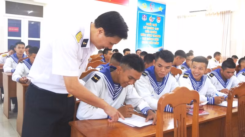 Chỉ huy Lữ đoàn hướng dẫn chiến sĩ trẻ làm bài kiểm tra nhận thức pháp luật.