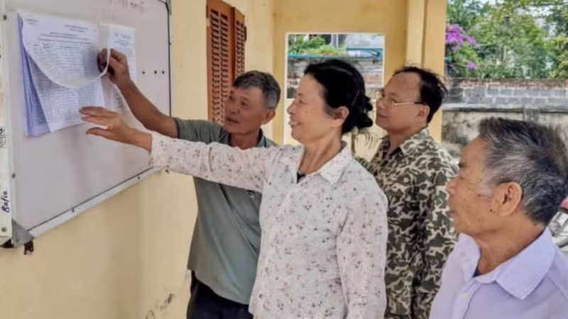 Cử tri xã Tự Tân (huyện Vũ Thư, tỉnh Thái Bình) xem niêm yết danh sách cử tri tham gia lấy ý kiến vào ngày 22/4 về sắp xếp đơn vị hành chính các cấp. (Ảnh: TIÊN DUNG)