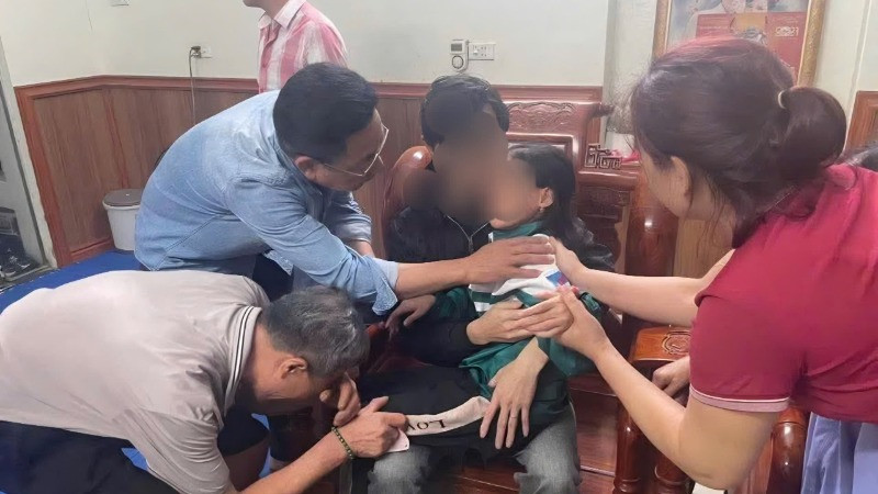 Cháu bé trong vòng tay gia đình sau cuộc giải cứu.