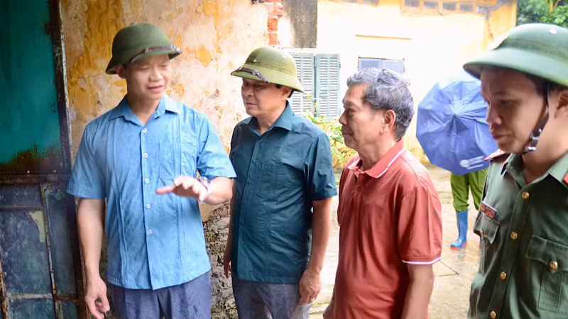 Chủ tịch Ủy ban nhân dân tỉnh Bắc Ninh (áo xanh ngoài cùng bên trái) vận động người dân đến nơi trú tránh an toàn.
