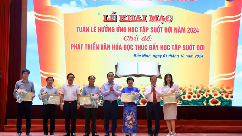 Ban tổ chức trao giấy chứng nhận, tặng hoa cảm ơn các đơn vị tặng sách.