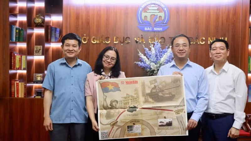 Đồng chí Nguyễn Thế Sơn, Giám đốc Sở Giáo dục và Đào tạo Bắc Ninh (thứ hai từ phải qua) tiếp nhận phụ san do Văn phòng đại diện Báo Nhân Dân tại Bắc Ninh trao tặng.