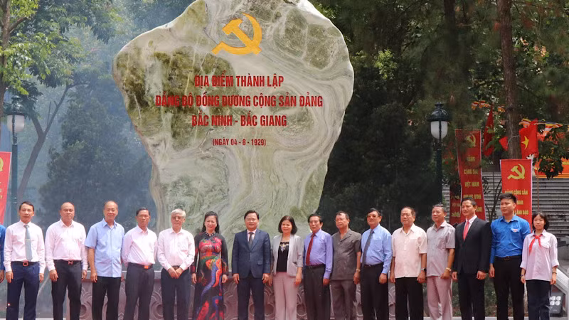 Các đại biểu chụp ảnh lưu niệm bên Bia ghi dấu địa điểm thành lập Đảng bộ Đông Dương Cộng sản Đảng Bắc Ninh-Bắc Giang.