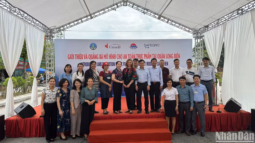 Các đại biểu chụp ảnh tại sự kiện quảng bá và giới thiệu mô hình chợ an toàn thực phẩm (ATTP) tại quận Long Biên.
