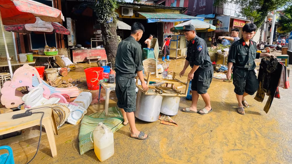 Chiến sĩ Cảnh sát Cơ động tham gia hỗ trợ nhân dân thành phố dọn vệ sinh môi trường tại phường Nguyễn Thái Học. (Ảnh: THANH SƠN)