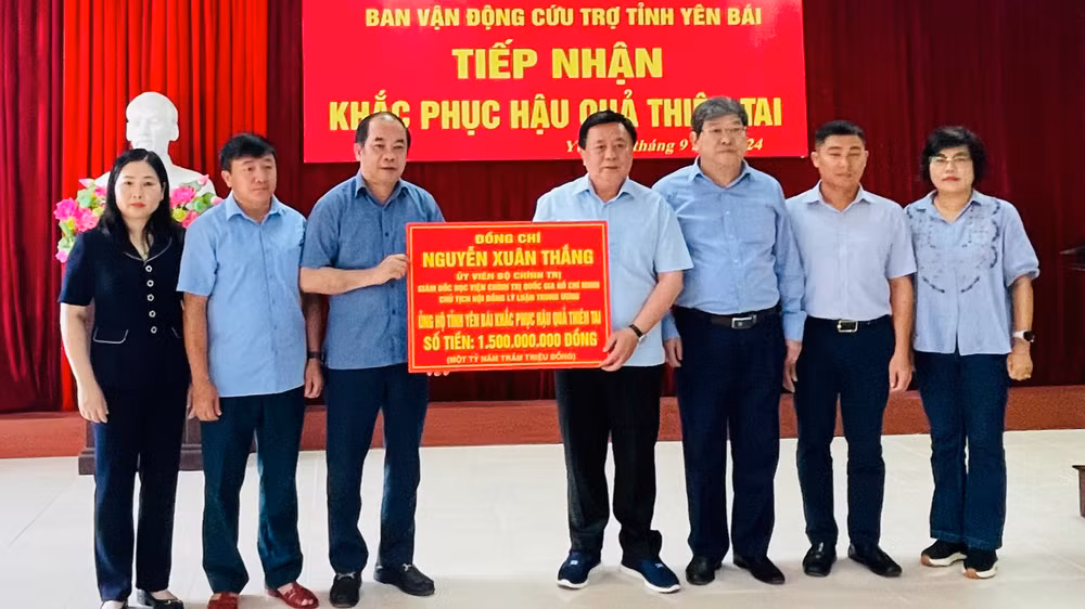 Đồng chí Nguyễn Xuân Thắng, Ủy viên Bộ Chính trị, Giám đốc Học viện Chính trị quốc gia Hồ Chí Minh trao 1,5 tỷ đồng khắc phục hậu quả thiên tai. (Ảnh: THANH SƠN)