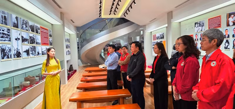 Các đại biểu, du khách nghe giới thiệu về sự kiện tập kết năm 1954 cùng các hiện vật, hình ảnh, tư liệu lịch sử.
