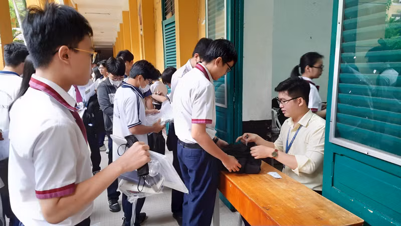 Các thí sinh làm thủ tục gửi đồ ở khu vực giữ vật dụng cho thí sinh tại điểm thi Trường trung học phổ thông Trưng Vương, quận 1. Các thí sinh làm thủ tục gửi đồ ở khu vực giữ vật dụng cho thí sinh tại điểm thi Trường trung học phổ thông Trưng Vương, quận 1.