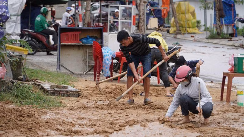 Người dân lấy nước về dọn bùn đất.