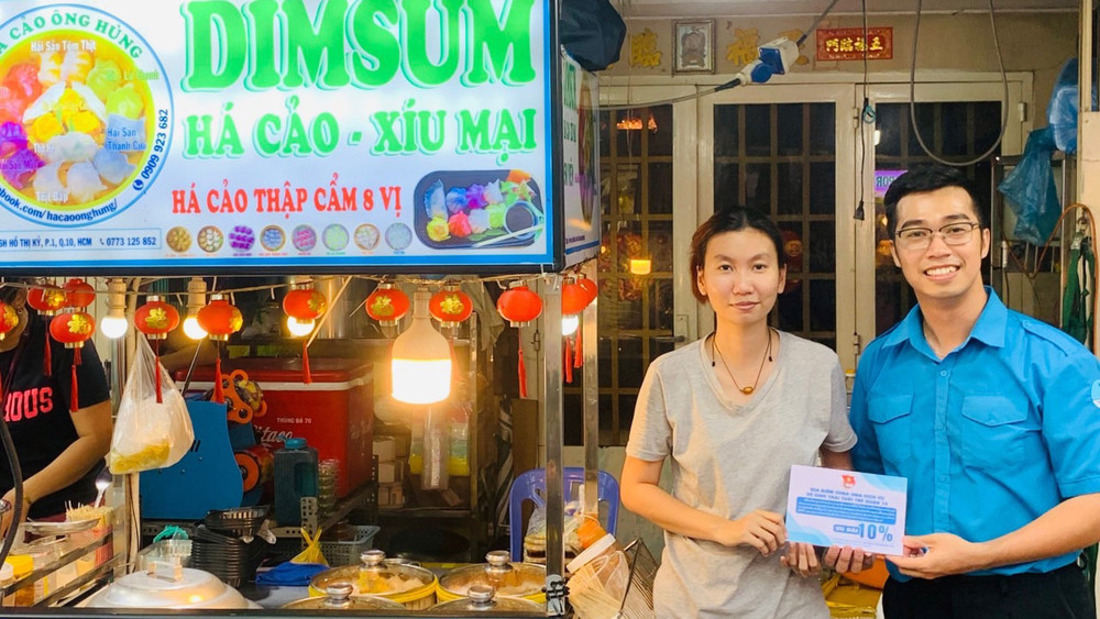 Đại diện Quận đoàn, Hội Liên hiệp thanh niên Quận 10 (TP Hồ Chí Minh) trao chứng nhận thành viên "Hệ sinh thái tuổi trẻ Quận 10" tặng các tiểu thương trên địa bàn. (Ảnh: Trang thông tin điện tử Trung ương Đoàn TNCS Hồ Chí Minh) 