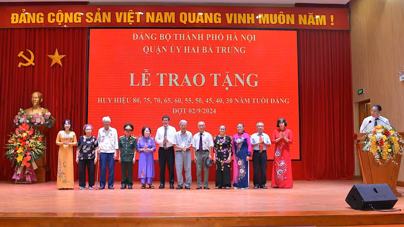 Đại diện Quận ủy trao tặng Huy hiệu 55 năm tuổi Đảng cho các đảng viên.