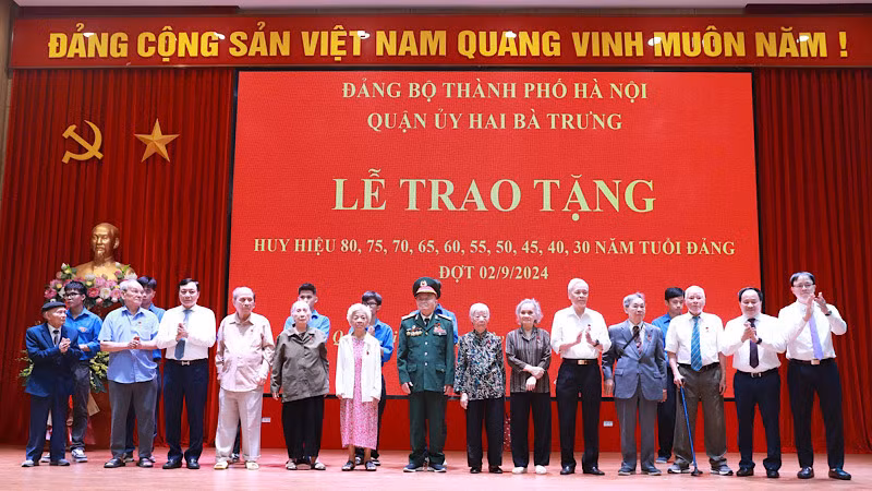 Đại diện Quận ủy Hai Bà Trưng trao tặng Huy hiệu Đảng và hoa chúc mừng 8 đồng chí đảng viên 75 năm, 70 năm tuổi đảng.