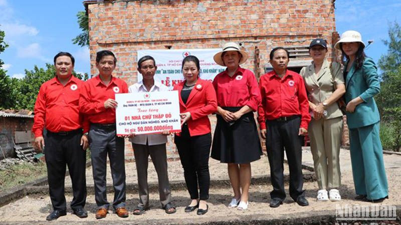 Trao biểu trưng hỗ trợ xây nhà Chữ thập đỏ cho ngư dân nghèo ở xã Đức Minh, huyện Mộ Đức. 