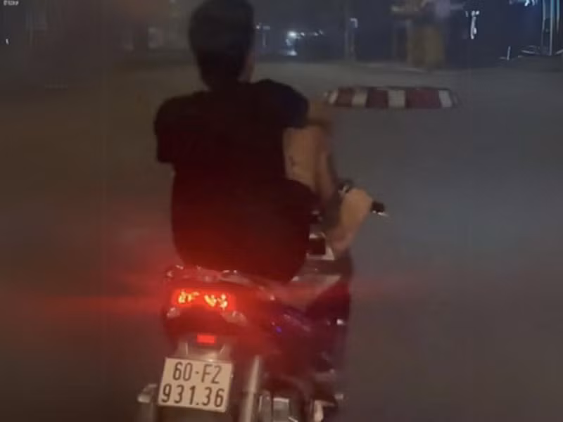 Võ Văn Tâm dùng chân điều khiển xe máy trên đường Hà Huy Giáp.