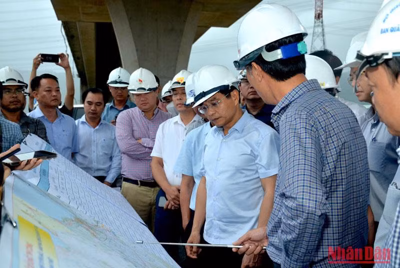 Bộ trưởng Nguyễn Văn Thắng (thứ 2 từ phải sang) nghe đại diện Ban quản lý Dự án 7 báo cáo tiến độ thi công cao tốc đoạn Vĩnh Hảo-Phan Thiết.