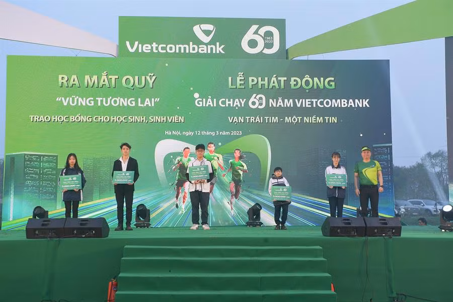 Ông Nguyễn Thanh Tùng - Thành viên Hội đồng quản trị, Tổng Giám đốc Vietcombank (ngoài cùng bên phải) trao học bổng cho các em học sinh nghèo vượt khó, tài năng.