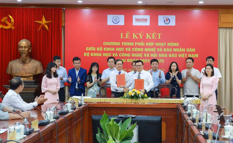 Tổng Biên tập Báo Nhân Dân Lê Quốc Minh và Bộ trưởng Khoa học và Công nghệ Huỳnh Thành Đạt trao biên bản ký kết.