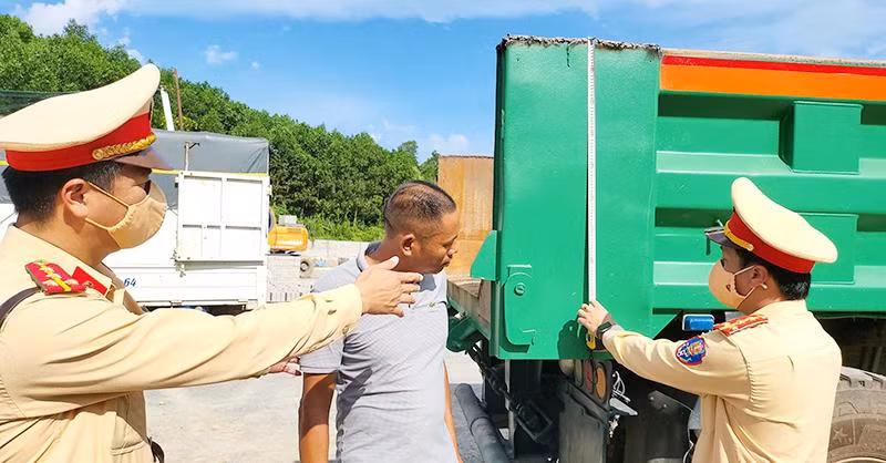 Lực lượng Cảnh sát giao thông Công an tỉnh Quảng Ninh xử phạt vi phạm và yêu cầu chủ phương tiện cắt bỏ thành thùng xe cơi nới không đúng quy định.