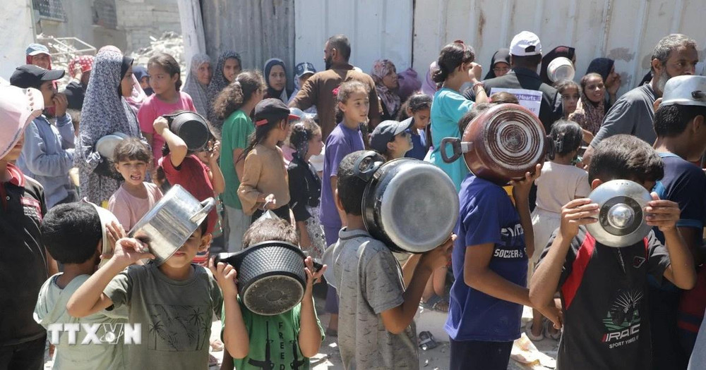 Trẻ em xếp hàng nhận thức ăn cứu trợ tại trại tị nạn Jabalia ở Dải Gaza. (Ảnh: THX/TTXVN)