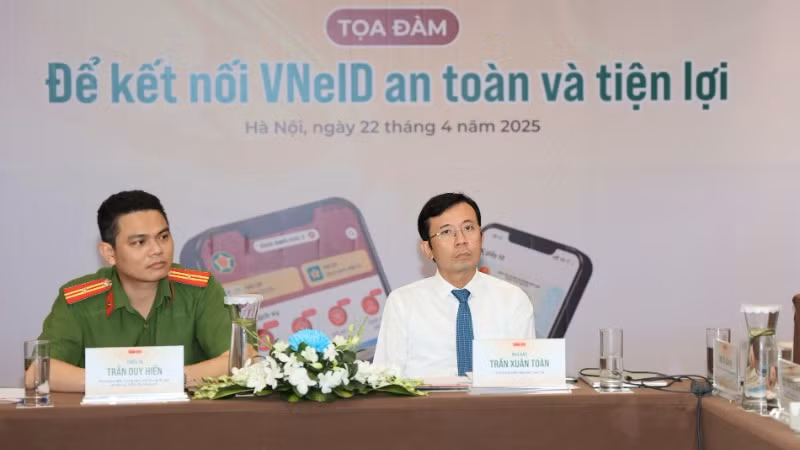 Thiếu tá Trần Duy Hiển, phó giám đốc Trung tâm dữ liệu quốc gia về dân cư (bên trái) và Phó tổng biên tập Báo Tuổi trẻ Trần Xuân Toàn tại buổi tọa đàm