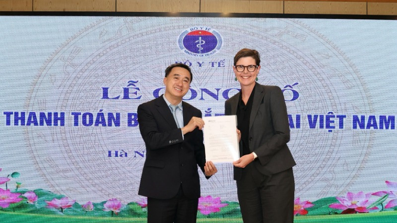 Trưởng đại diện Tổ chức Y tế Thế giới tại Việt Nam (bên phải) trao chứng nhận thanh toán thành công bệnh mắt hột tại Việt Nam cho Thứ trưởng Y tế Trần Văn Thuấn.