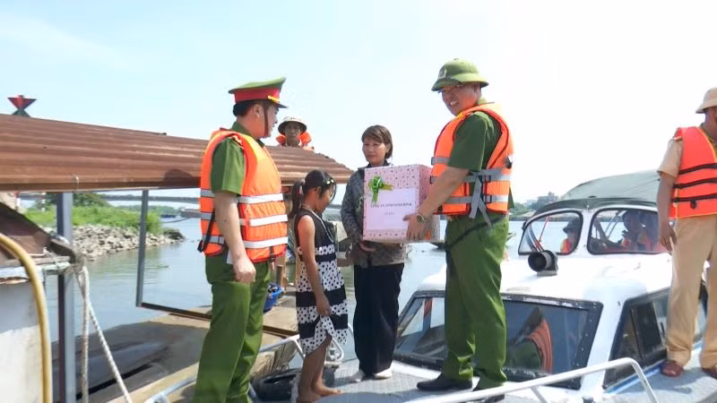 Đại tá Tống Như Sơn, Phó Giám đốc, Thủ trưởng cơ quan Cảnh sát điều tra công an tỉnh Ninh Bình cùng đoàn công tác trao quà hỗ trợ người dân trên sông Đáy. (Ảnh: ĐỨC THẮNG)