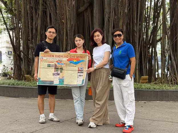 Bạn đọc nhận phụ san và chụp ảnh tại gốc đa Hàng Trống.