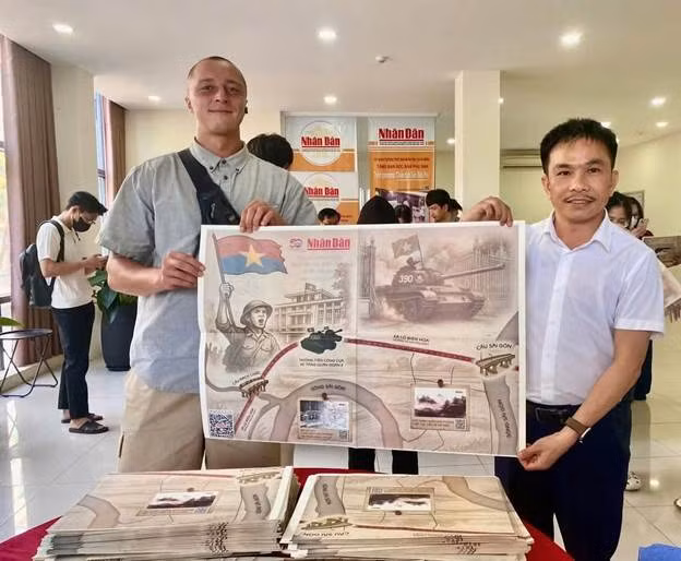 Du khách nước ngoài hồ hởi với bản phụ san ở cơ quan đại diện của Báo Nhân Dân tại miền trung-Tây Nguyên.