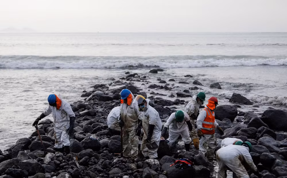 Công nhân dọn dẹp bãi biển gần nhà máy lọc dầu La Pampilla của Repsol sau sự cố tràn dầu gần đây gây ra thảm họa sinh thái trên bờ biển Lima, ở Ventanilla, Peru ngày 29/1/2022. Ảnh chụp bằng drone. REUTERS