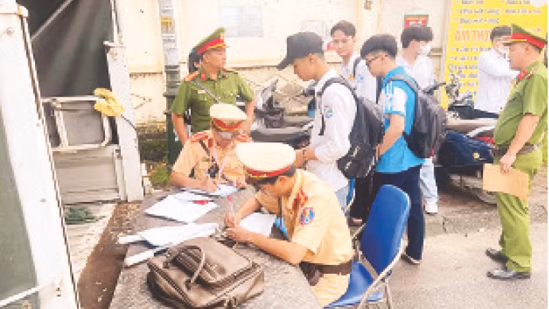 Học sinh vi phạm Luật Giao thông đường bộ bị Đội Cảnh sát giao thông-trật tự (Công an huyện Mỹ Đức) lập biên bản xử phạt. (Ảnh Phạm Công)