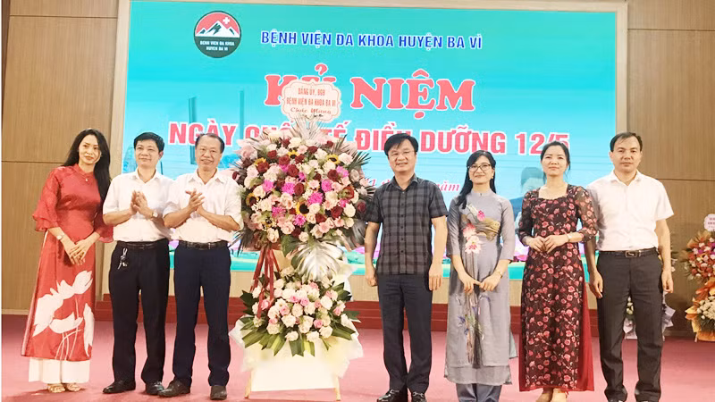 Lãnh đạo Bệnh viện Đa khoa huyện Ba Vì trao tặng lẵng hoa cho các điều dưỡng công tác tại đơn vị.