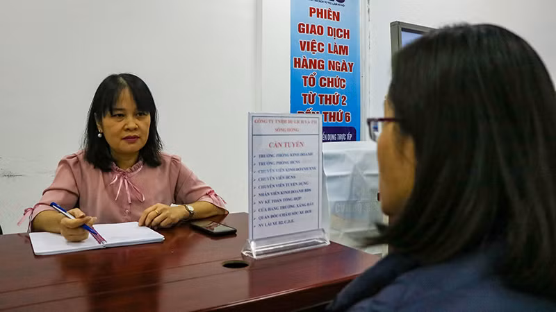 Người lao động tìm hiểu thông tin tại doanh nghiệp trong phiên giao dịch việc làm ngày 9/3. (Ảnh: Nhật Quang)