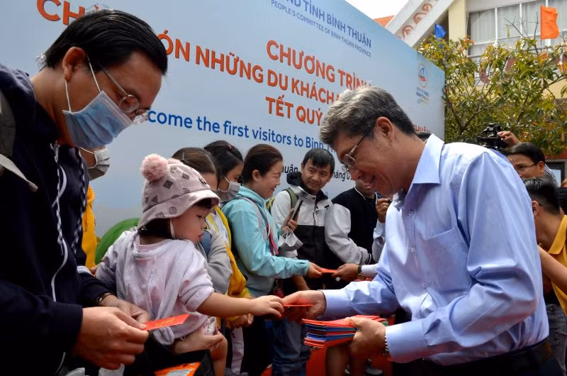 Ông Nguyễn Minh, Phó Chủ tịch Ủy ban nhân dân tỉnh Bình Thuận trao tận tay những phong bao lì xì cho hành khách vừa xuống tàu.