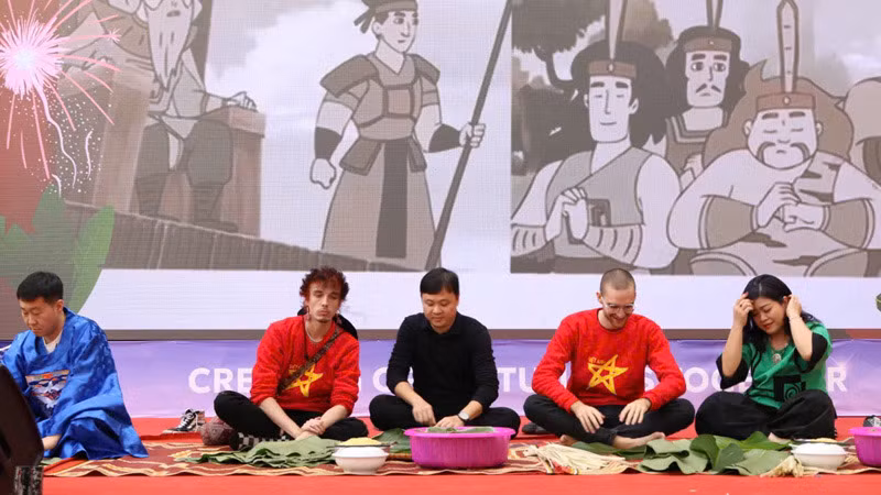 Các thầy cô của Trường đại học Ngoại ngữ, Đại học Quốc gia Hà Nội hướng dẫn các đồng nghiệp quốc tế cách gói bánh chưng, quảng bá nét đẹp văn hóa Việt Nam.